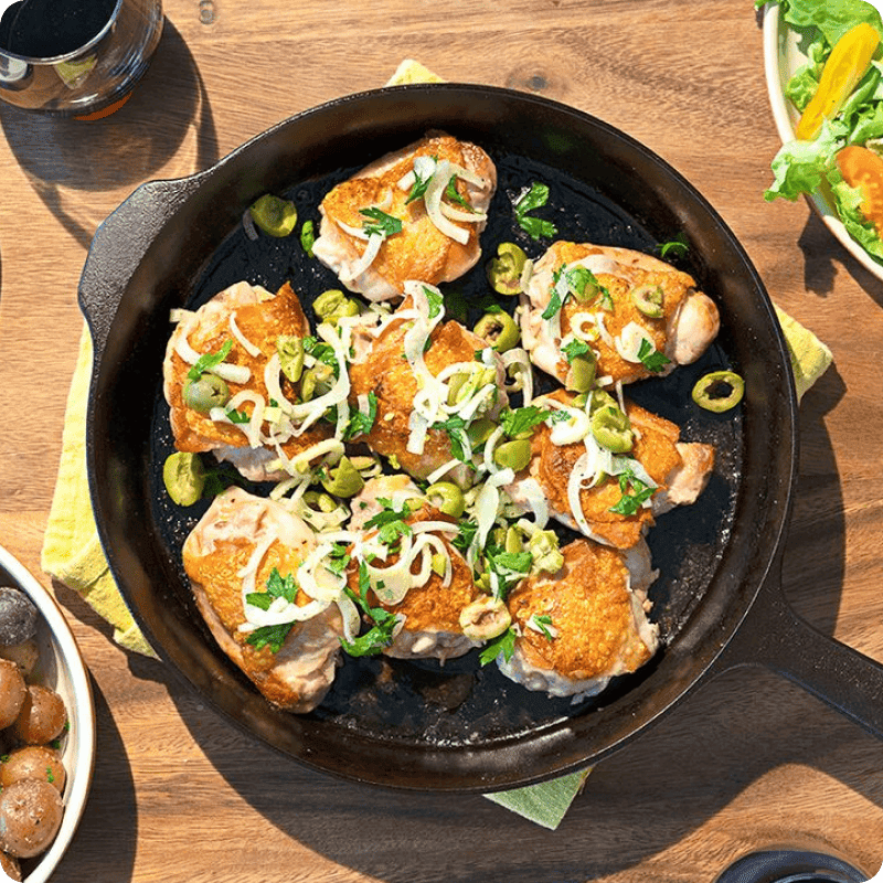 Skillet-seared chicken thighs with olives and herbs — order chicken online for easy, flavorful weeknight dinners.