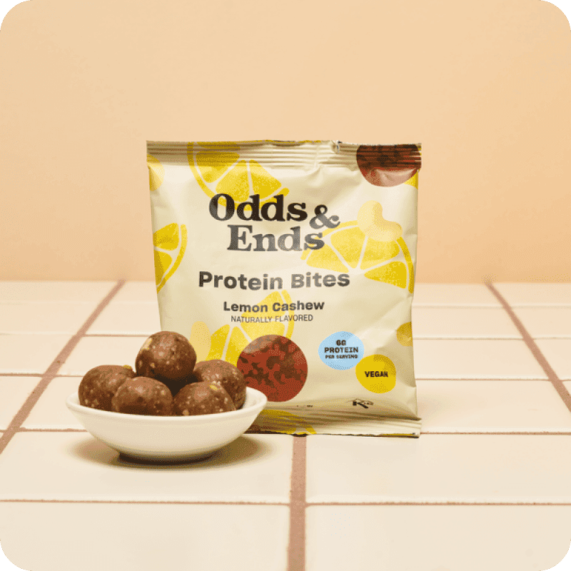 Odds & Ends Lemon Cashew Vegan Protein Bites bag with protein bites in a bowl — buy protein bars online from Misfits Market