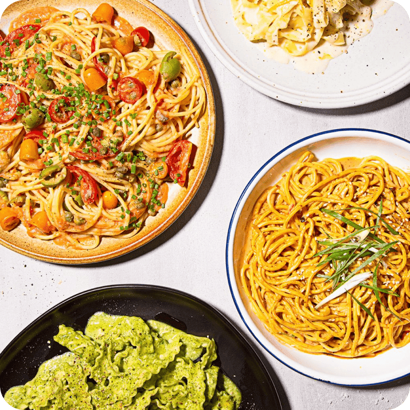 Four pasta dishes made with sauces delivery ingredients including tomato, creamy white, and pesto.