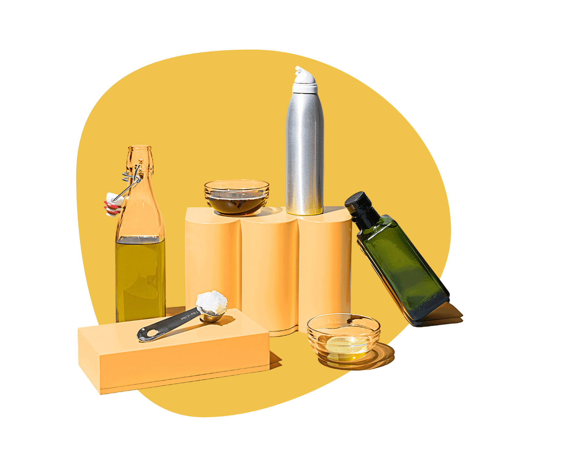 Assortment of cooking oils including olive oil and coconut oil displayed on yellow pedestals, shop cooking oil delivery from Misfits Market.